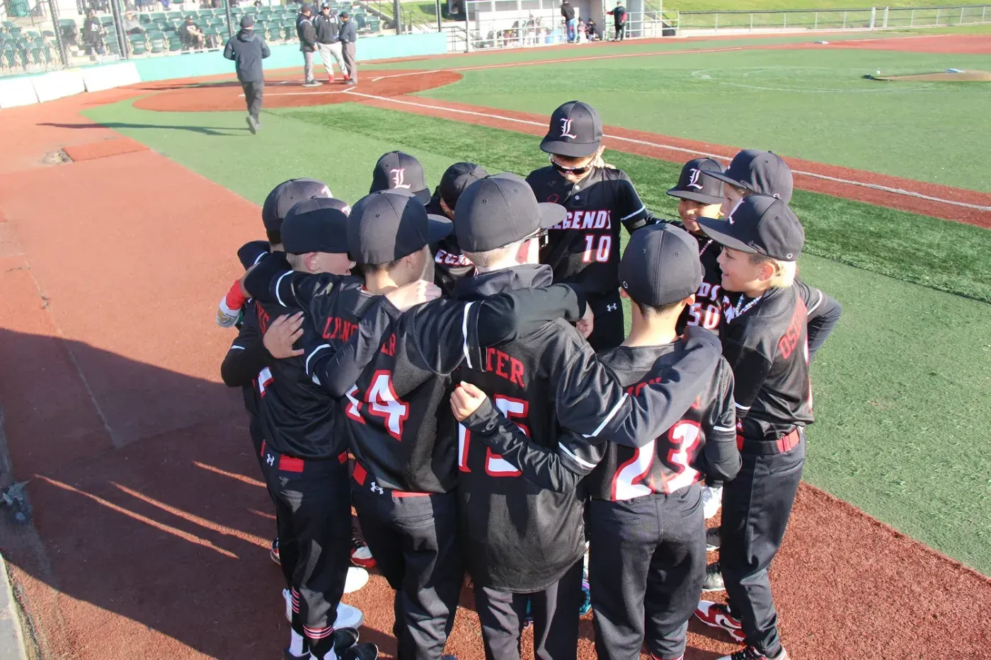 Legends baseball players huddled on the field