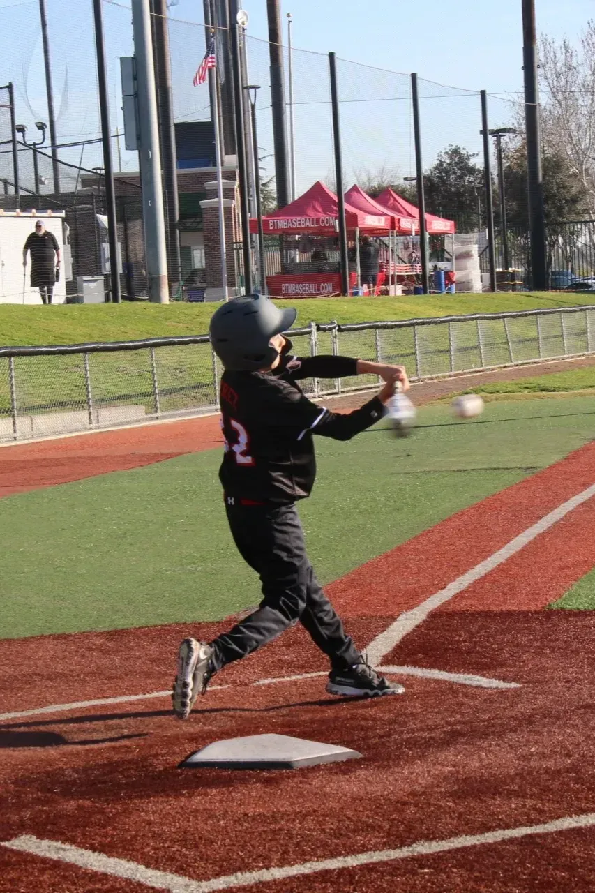 A young Legends batter in mid-swing