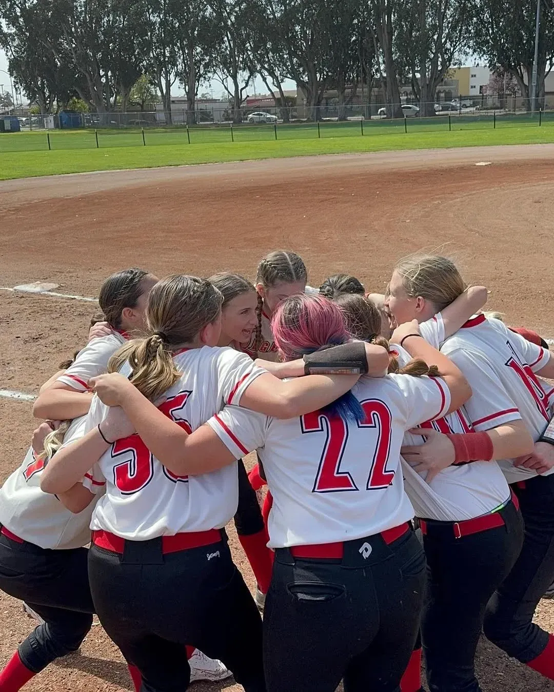 Legends softball players celebrating in a huddle