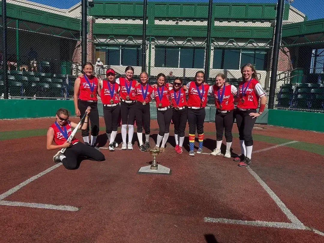 Legends softball players celebrating with a trophy
